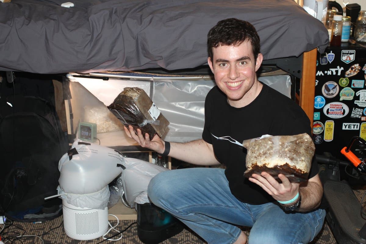 Monty Singer holding mushroom-grow blocks from an early dorm-room project
